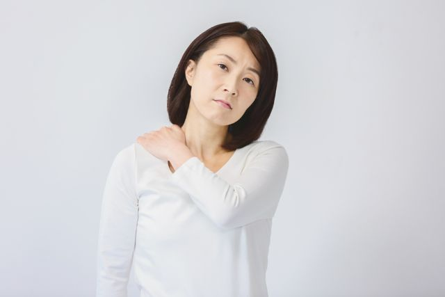 肩をおさえてる白い服の女性