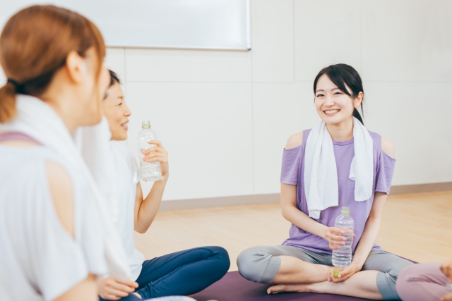 運動後に地面に座って休憩している三人
