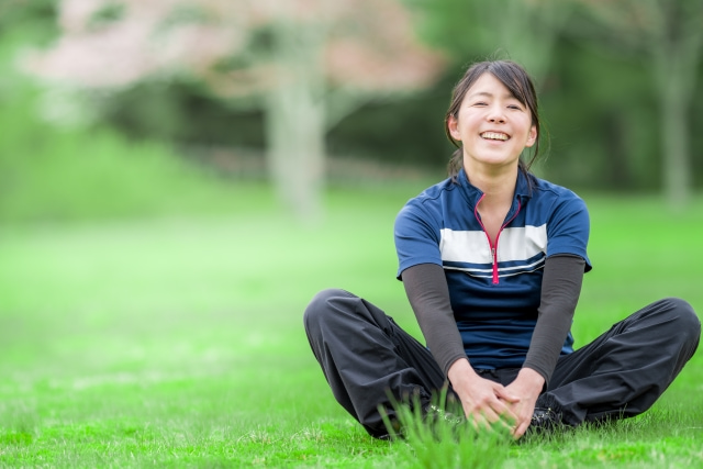 芝生に座っている笑顔の女性