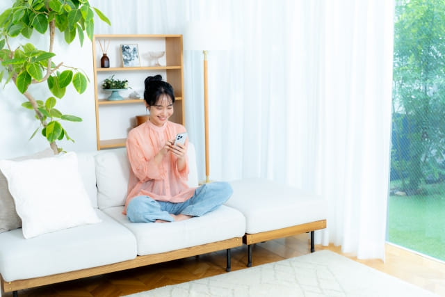 女性が座ってスマホを見ている様子