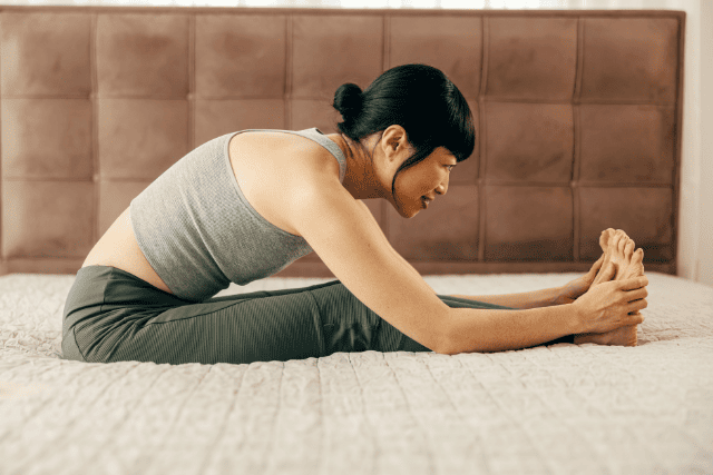 部屋でストレッチする女性